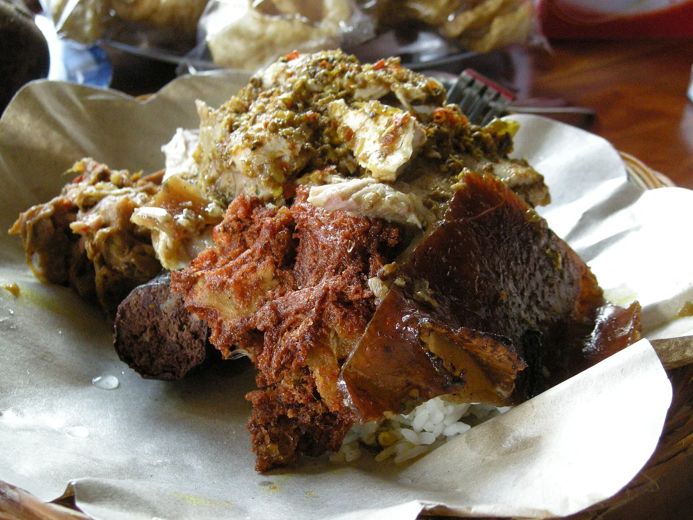 A close-up plate of babi guling, Balinese spit-roast suckling pig, with crackling and sambal