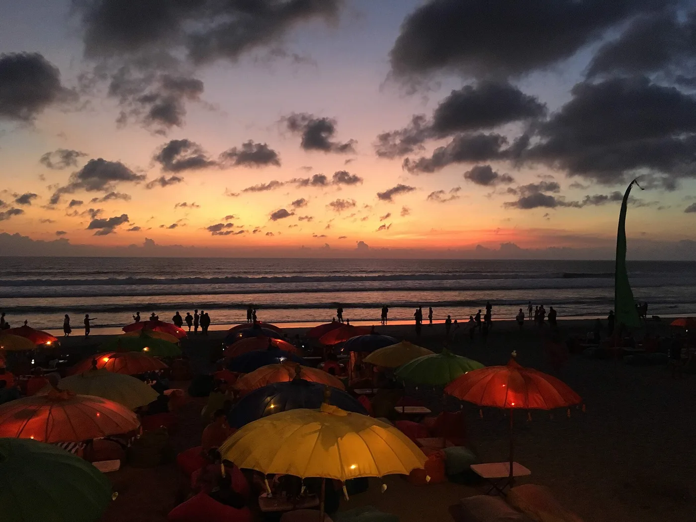 Colourful beach-club umbrellas and beanbags on Seminyak beach at sunset