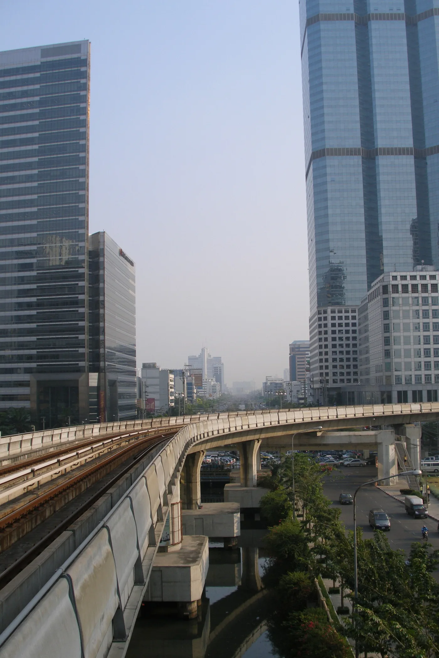 The elevated BTS Skytrain viaduct curving through central Bangkok above the traffic