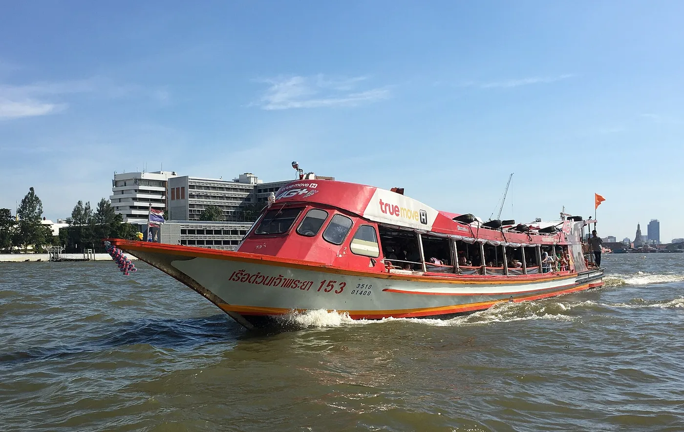 An orange-flag Chao Phraya Express Boat under way on the river