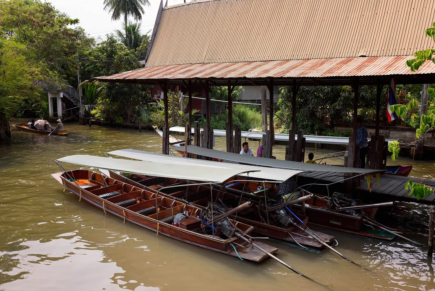 Long-tail boats at a canal pier at the Damnoen Saduak floating market