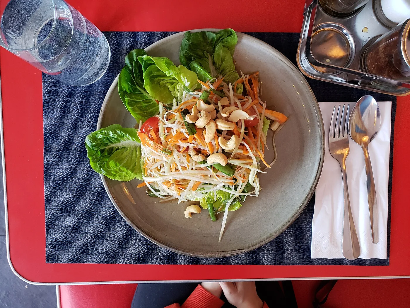 A plate of shredded green papaya salad (som tam) with tomatoes and nuts