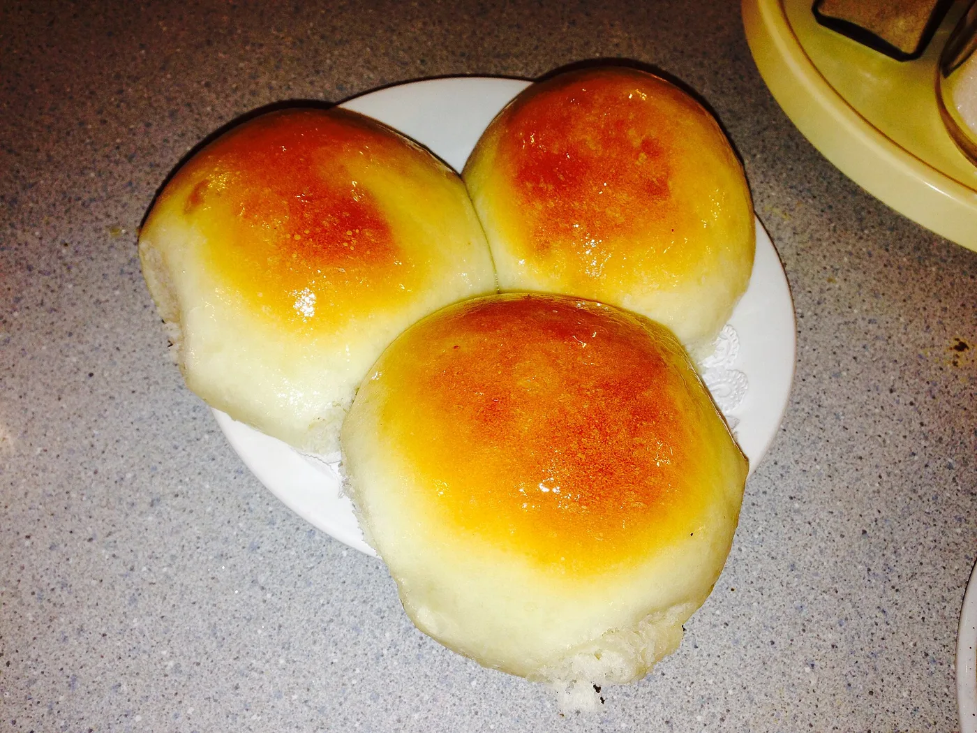 Three glazed baked char siu bao on a plate