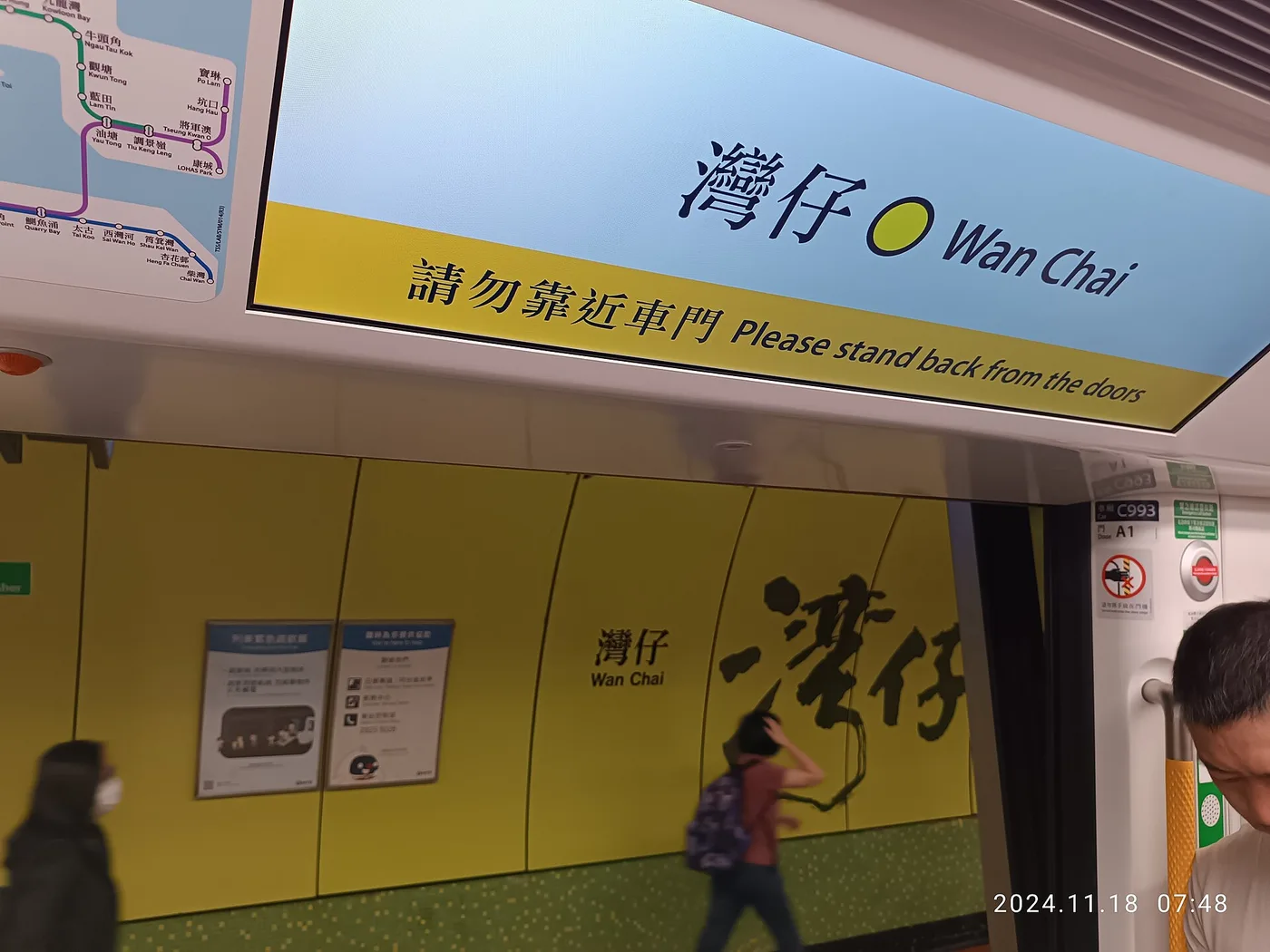 An MTR train and platform with bilingual station signage