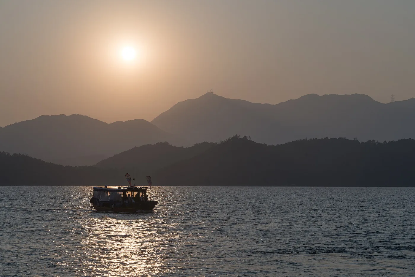 The Sai Kung coast and hills from Sharp Island Pier, a small boat on the water