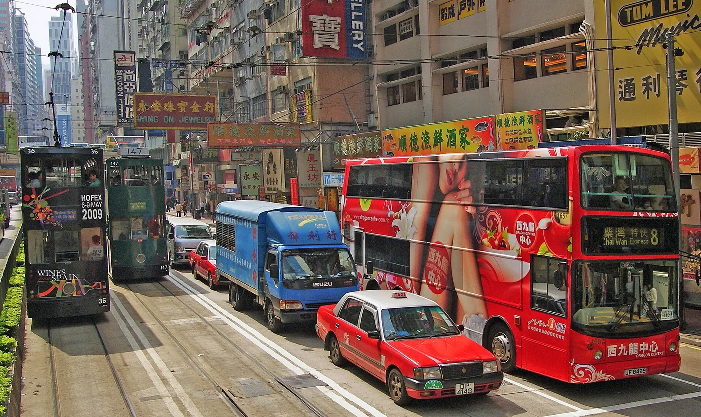 Green double-decker trams on a Hong Kong Island street