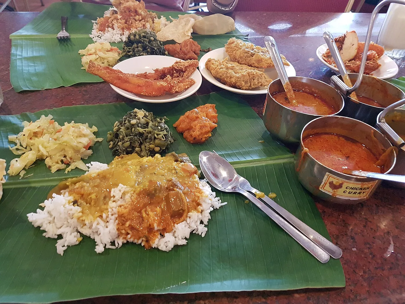 A banana-leaf meal piled with rice, curry, sauteed greens and fried sides