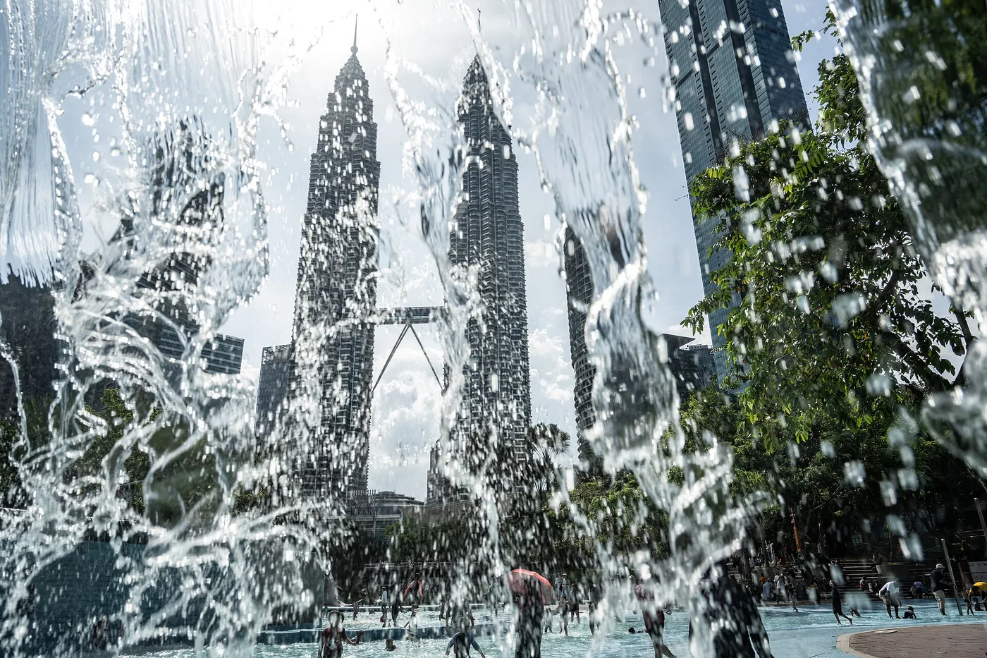 The Petronas Twin Towers seen through the spray of the KLCC Park pool fountain