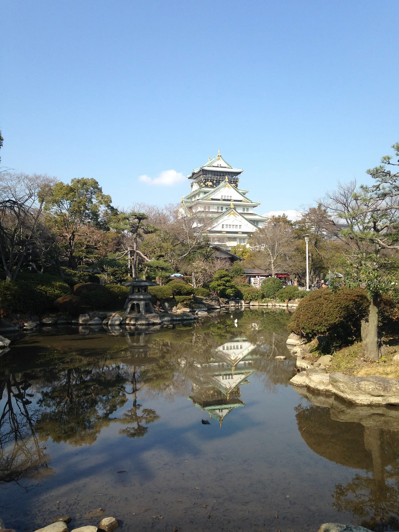 Osaka Castle's keep reflected in a garden pond in Osaka Castle Park