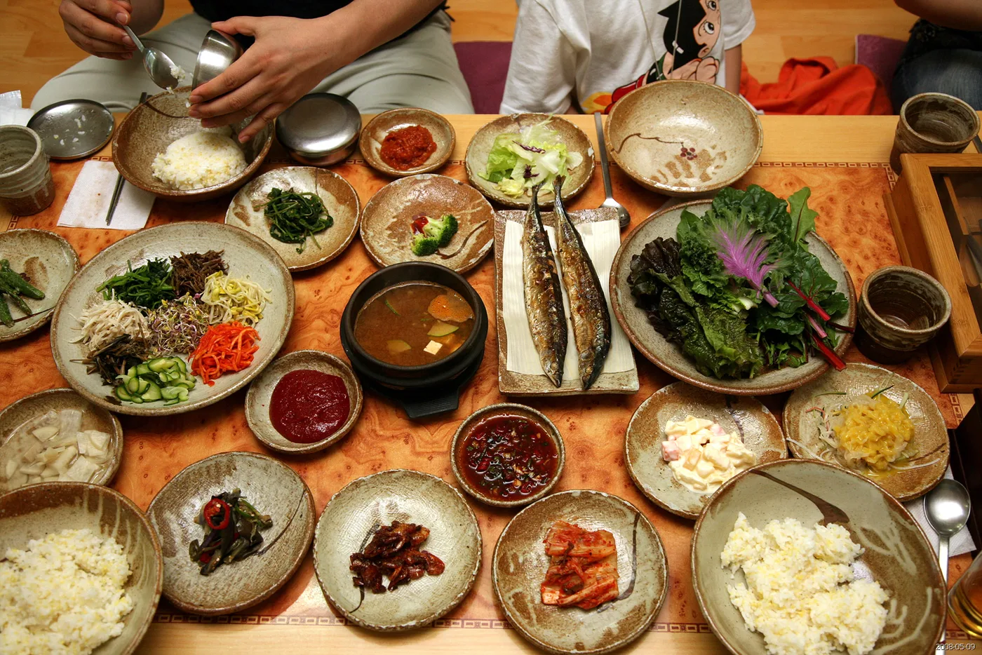 A spread of banchan side dishes around a Korean meal
