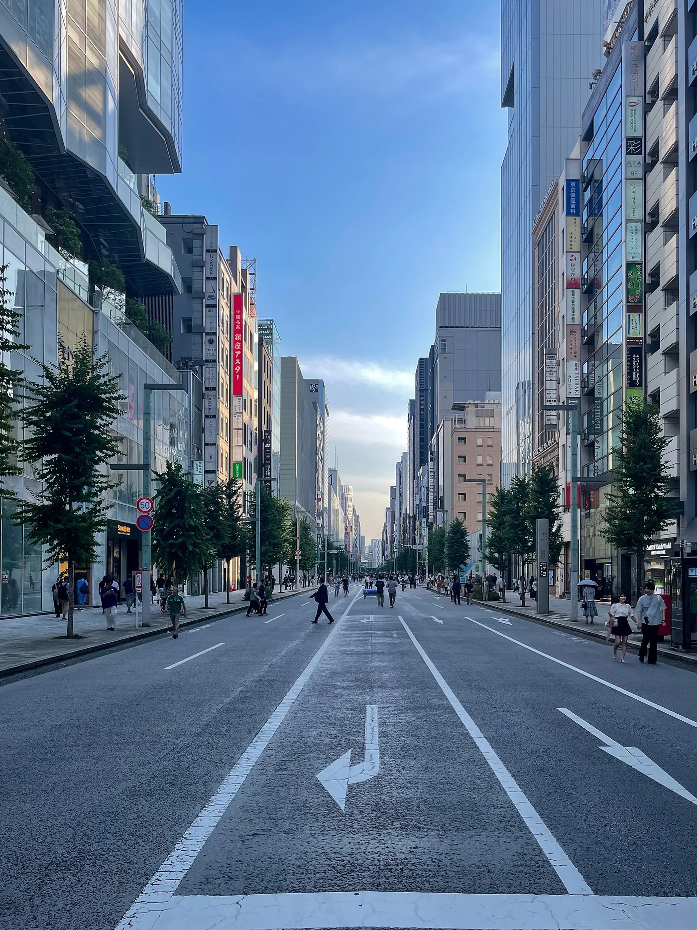 Ginza's Chūō-dōri, a wide tree-lined street closed to traffic with people walking in the road