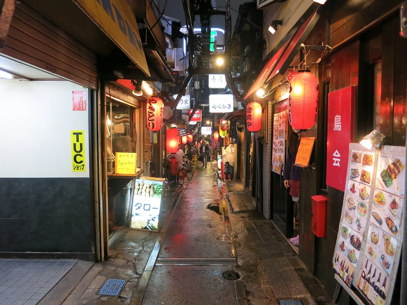 A lantern-lit yakitori alley at night, tiny stalls under red lanterns